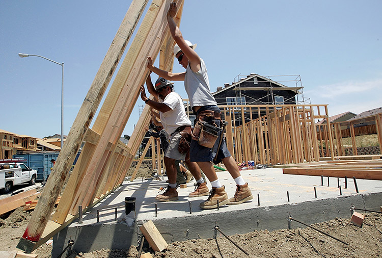 RICHMOND, CA - JUNE 26:  Construction workers raise wood framing as they build homes in a new housing development June 26, 2006 in Richmond, California. A report issued by the U.S. Commerce Department stated that sales of new single-family homes were up 4.6 percent in May. The median price of homes sold in May slipped to $235,300, down 4.3 percent from April.  (Photo by Justin Sullivan/Getty Images)